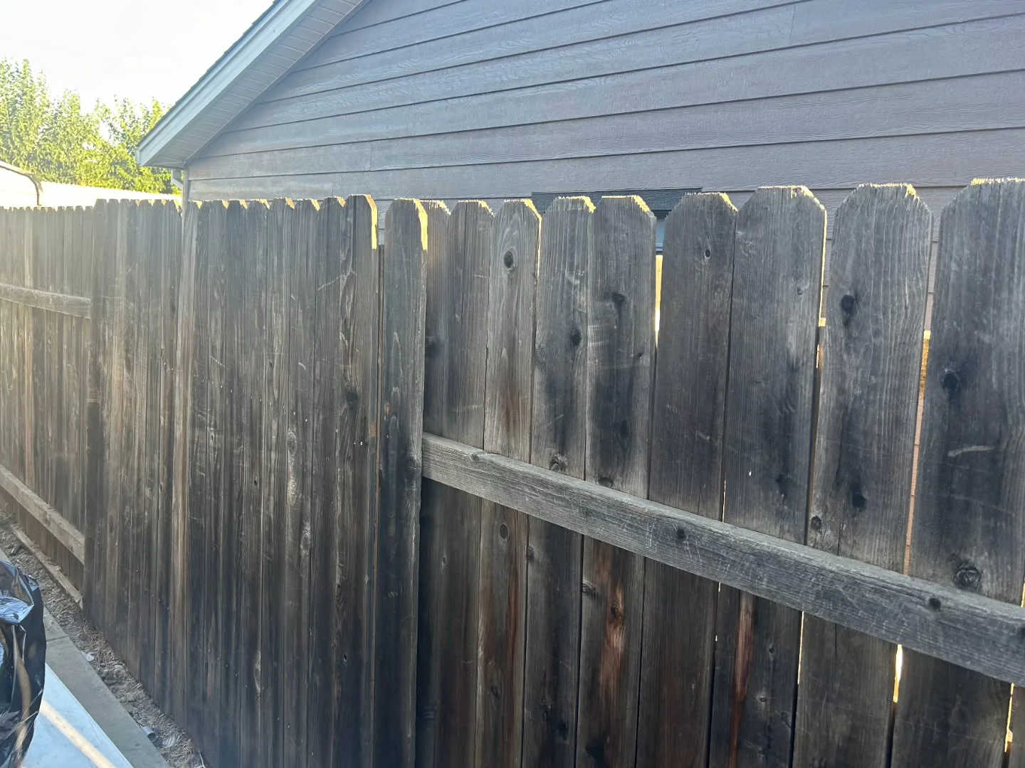 A weathered gray fence before Matt cleaned it